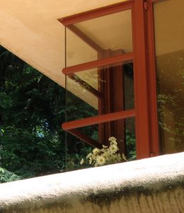 White flowers in the window with red framing